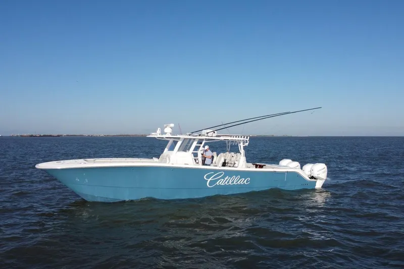 Catallac Yacht Photos Pics 2023 Invincible 46 Catamaran on open water, clear blue sky, side view.