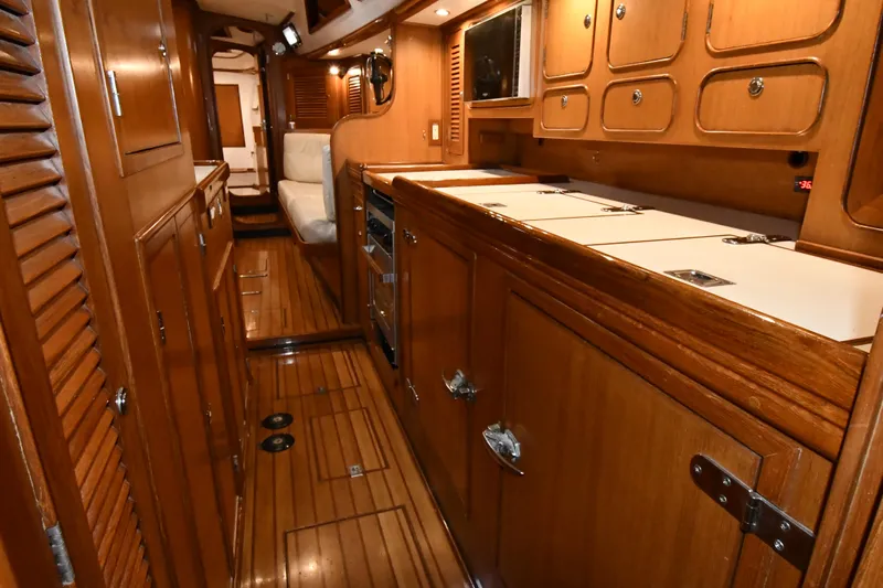 Matilida Yacht Photos Pics Luxurious wooden interior of a 2002 Hylas 46 yacht, featuring elegant cabinetry and seating.