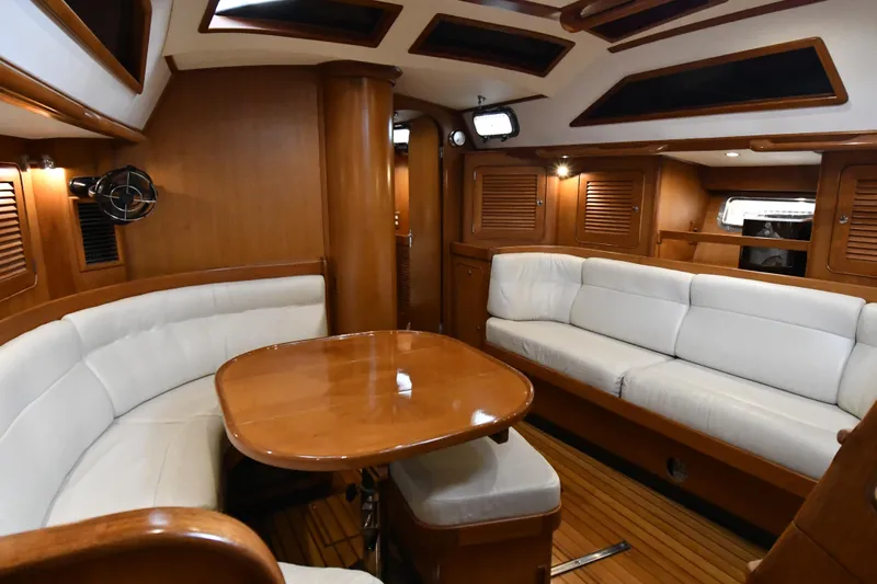 Matilida Yacht Photos Pics Luxurious interior of a 2002 Hylas 46 yacht with wooden finishes and white seating.