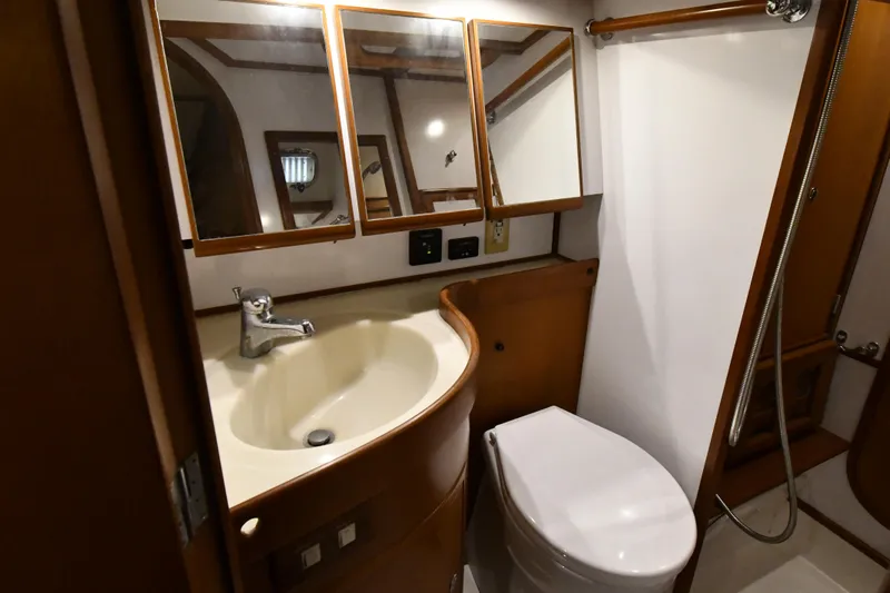 Matilida Yacht Photos Pics Bathroom interior of a 2002 Hylas 46 yacht, featuring sink, mirror, and toilet.