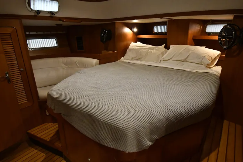 Matilida Yacht Photos Pics Luxurious cabin interior of 2002 Hylas 46 yacht with cozy bed and wooden finish.