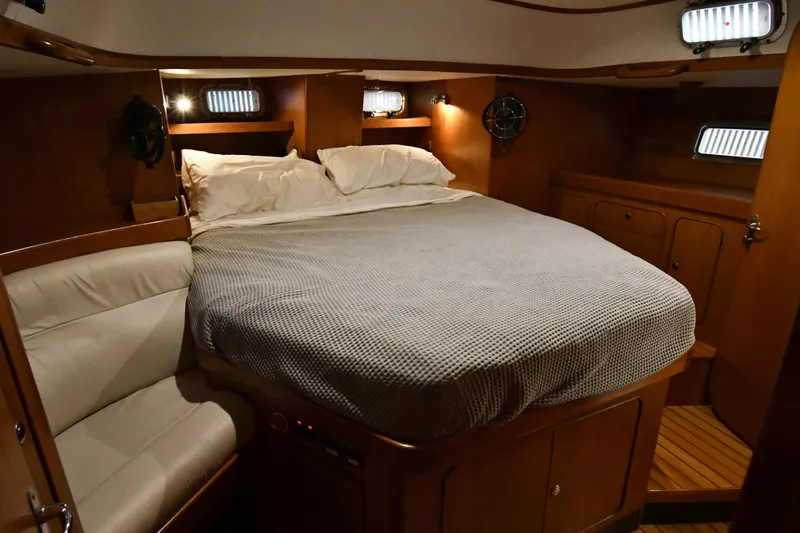 Matilida Yacht Photos Pics Luxurious cabin interior of a 2002 Hylas 46 yacht with cozy bedding and wood finish.