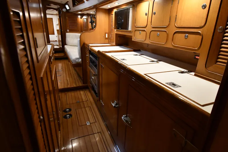Matilida Yacht Photos Pics Interior of a 2002 Hylas 46 yacht with wooden cabinetry and seating area.