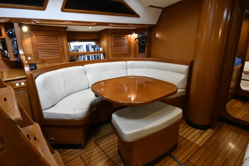 Matilida Yacht Photos Pics Luxurious interior of a 2002 Hylas 46 yacht with wooden finishes and white seating.