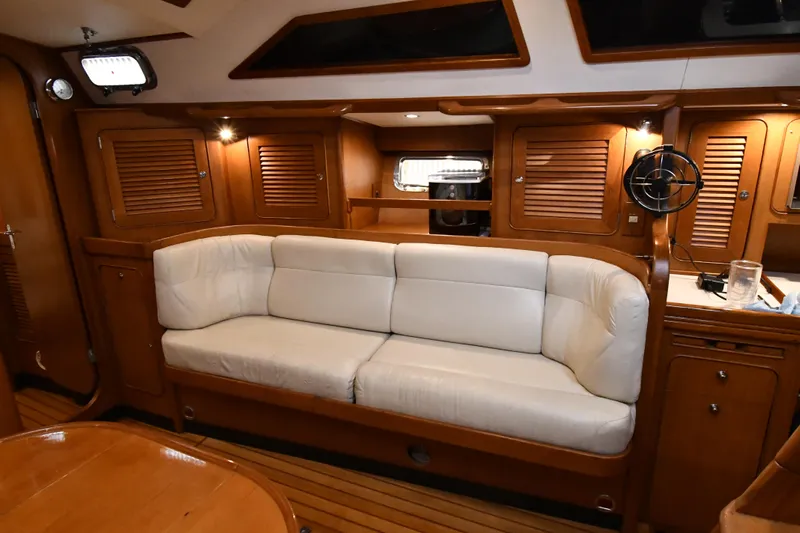 Matilida Yacht Photos Pics Luxurious interior of a 2002 Hylas 46 yacht with white sofa and wooden cabinetry.