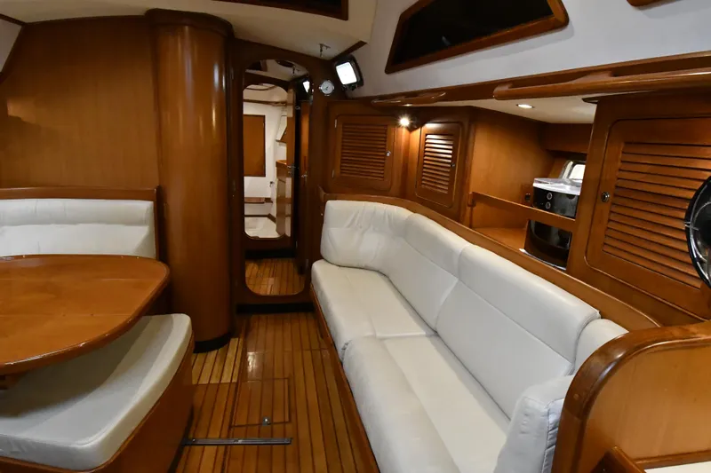 Matilida Yacht Photos Pics Luxurious interior of a 2002 Hylas 46 yacht with wooden finishes and white seating.