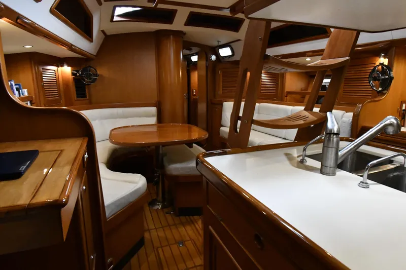 Matilida Yacht Photos Pics Luxurious interior of a 2002 Hylas 46 yacht with wood finish and seating area.
