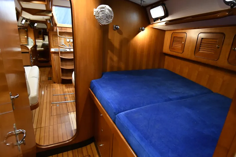 Matilida Yacht Photos Pics Interior of 2002 Hylas 46 yacht with wooden finish and blue bedding.