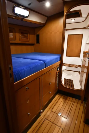 Matilida Yacht Photos Pics Cozy cabin interior of 2002 Hylas 46 yacht with wooden finish and blue bedding.