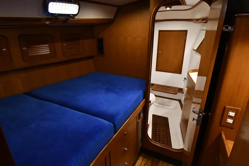 Matilida Yacht Photos Pics Cozy cabin interior of 2002 Hylas 46 yacht with blue bedding and wooden accents.