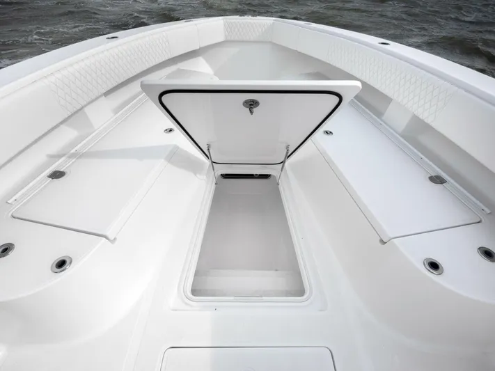 Bill Time Yacht Photos Pics 2016 Bahama 41 boat deck with open storage compartment, white interior, and ocean background.