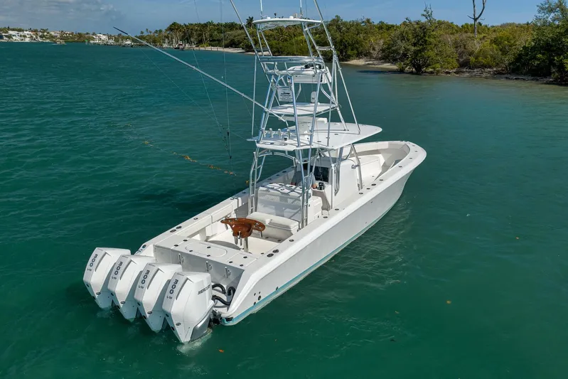 Bill Time Yacht Photos Pics 2016 Bahama 41 boat with four engines on turquoise water near lush shoreline.