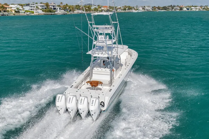 Bill Time Yacht Photos Pics 2016 Bahama 41 boat cruising on turquoise waters near coastal homes.