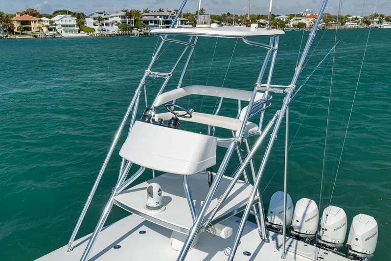 Bill Time Yacht Photos Pics 2016 Bahama 41 boat with tower and controls, docked near waterfront homes.