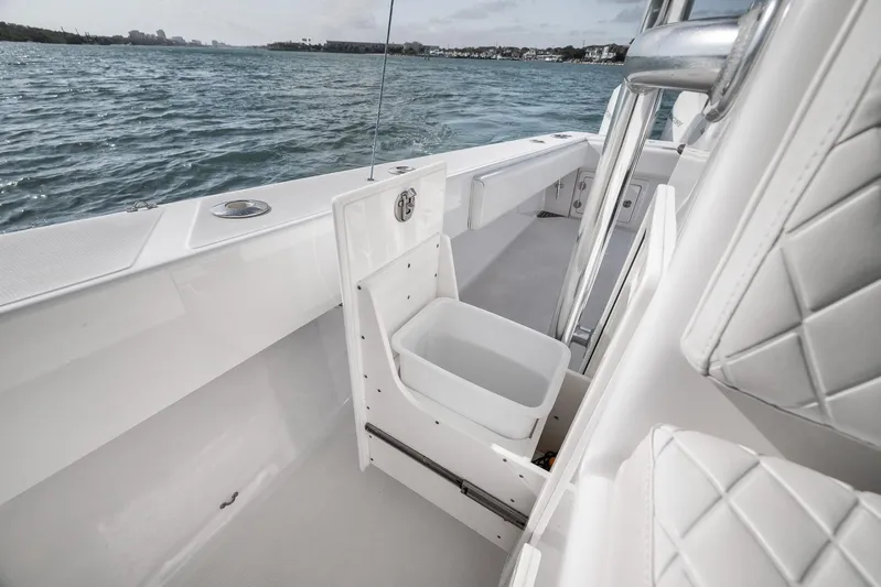 Bill Time Yacht Photos Pics 2016 Bahama 41 boat interior with open storage compartment, white seating, and ocean view.