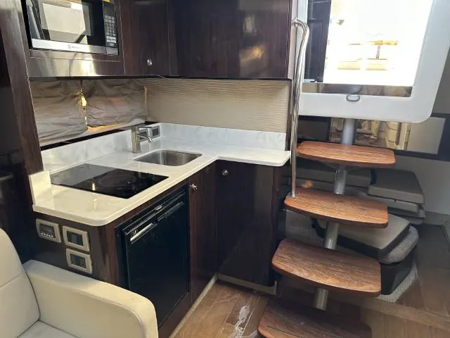  Yacht Photos Pics Interior of 2017 Sea Ray Sundancer 350 Coupe with modern kitchen and wooden stairs.