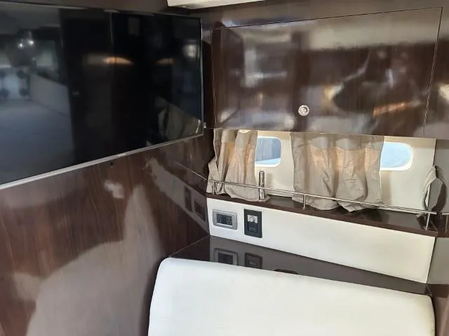  Yacht Photos Pics Interior of 2017 Sea Ray Sundancer 350 Coupe with dark wood paneling and small window.