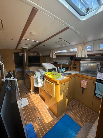 Pelican Pat Yacht Photos Pics Interior of 2010 Jeanneau Sun Odyssey 42i sailboat, featuring a cozy cabin with wooden finishes.