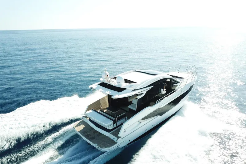  Yacht Photos Pics 2024 Galeon 410 HTC yacht cruising on open sea under bright sunlight.