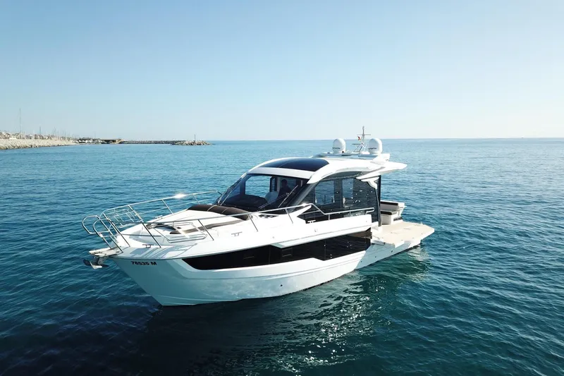  Yacht Photos Pics 2024 Galeon 410 HTC yacht cruising on clear blue ocean waters.