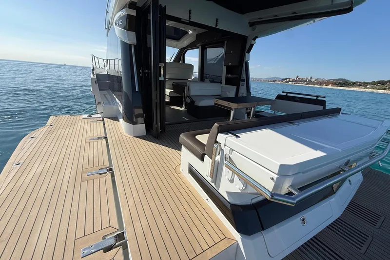  Yacht Photos Pics 2024 Galeon 410 HTC yacht with spacious deck and luxurious seating on calm waters.