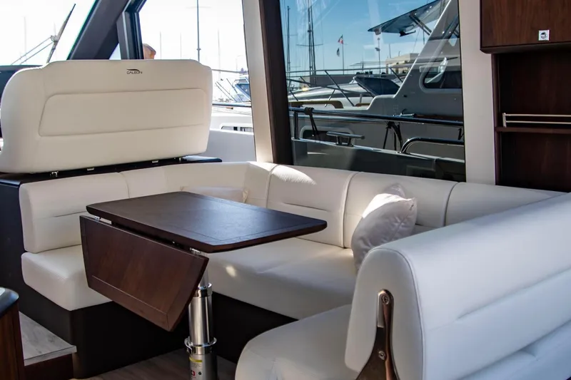  Yacht Photos Pics Luxurious interior of 2025 Galeon 410 HTC yacht with white seating and wooden table.