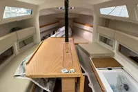Interior of 2011 Maree Haute DJANGO 770 sailboat with wooden table and seating.