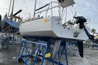 Sailboat Maree Haute DJANGO 770, 2011 model, on blue stands in a boatyard.