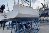 Sailboat Maree Haute DJANGO 770, 2011 model, on blue stands in a boatyard.