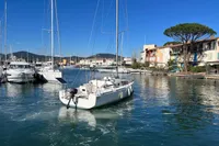 Sailboat Maree Haute DJANGO 770, 2011, in a scenic marina with clear blue skies.