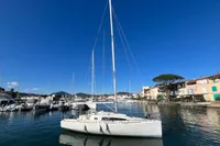 Sailboat Maree Haute DJANGO 770, 2011 model, docked in a scenic marina under clear blue skies.