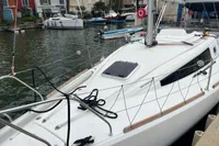 Sailboat Maree Haute DJANGO 770, 2011 model, docked in a marina with surrounding boats.