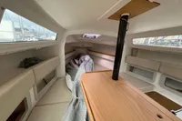 Interior of 2011 Maree Haute DJANGO 770 sailboat, featuring cozy seating and wooden table.