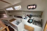 Interior of 2011 Maree Haute DJANGO 770 sailboat, featuring compact kitchen and storage area.