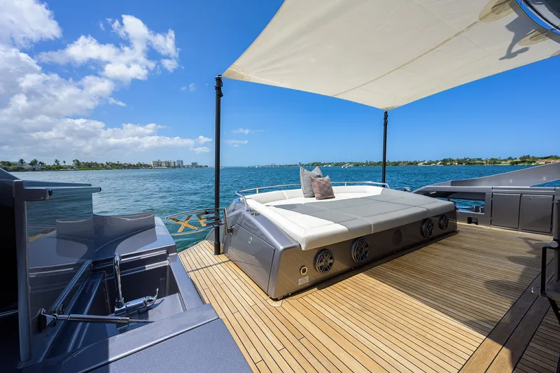 Shine Yacht Photos Pics Luxurious 2022 Pershing 9X yacht deck with sunbed, ocean view, and sleek design.