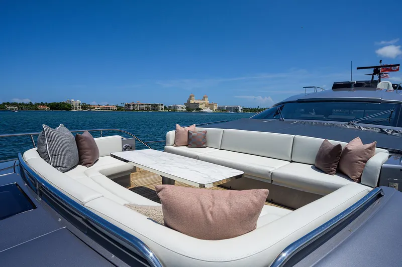 Shine Yacht Photos Pics Luxurious 2022 Pershing 9X yacht with elegant outdoor seating and scenic waterfront view.