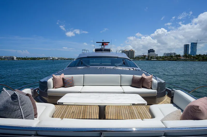 Shine Yacht Photos Pics Luxurious 2022 Pershing 9X yacht with elegant seating, cruising on a sunny day.