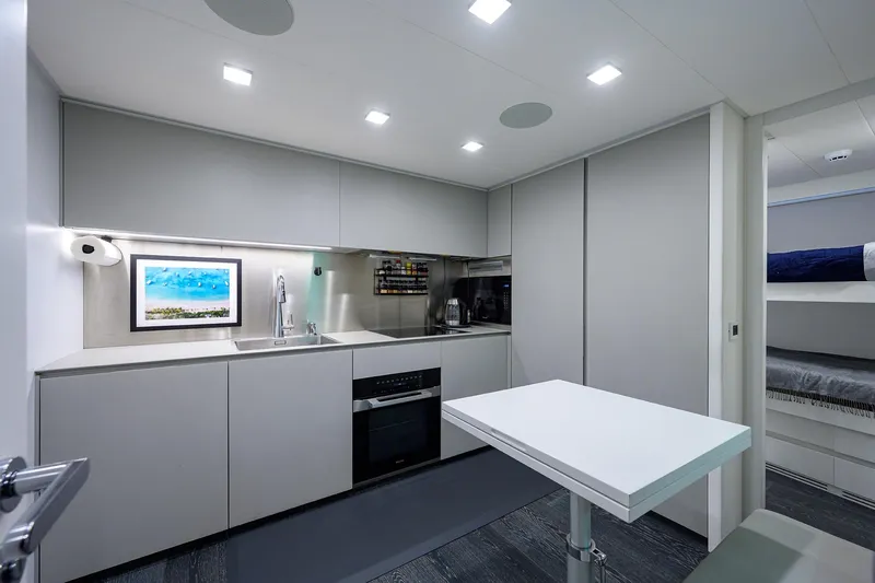 Shine Yacht Photos Pics Modern kitchen interior on 2022 Pershing 9X yacht with sleek design and bunk beds.