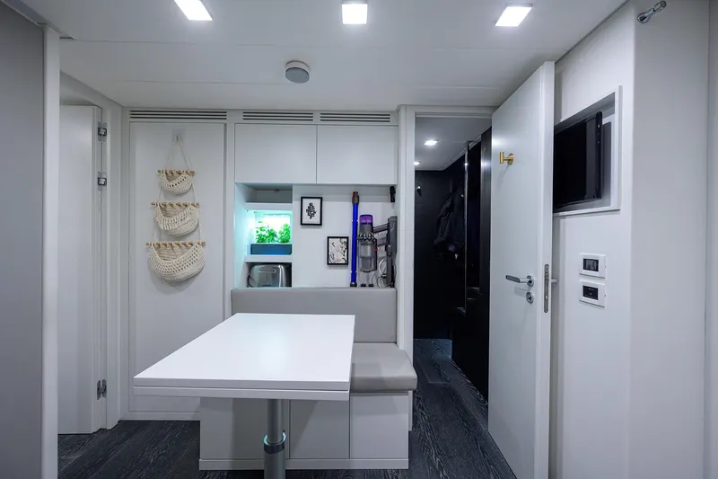 Shine Yacht Photos Pics Modern interior of 2022 Pershing 9X yacht with sleek design and compact dining area.