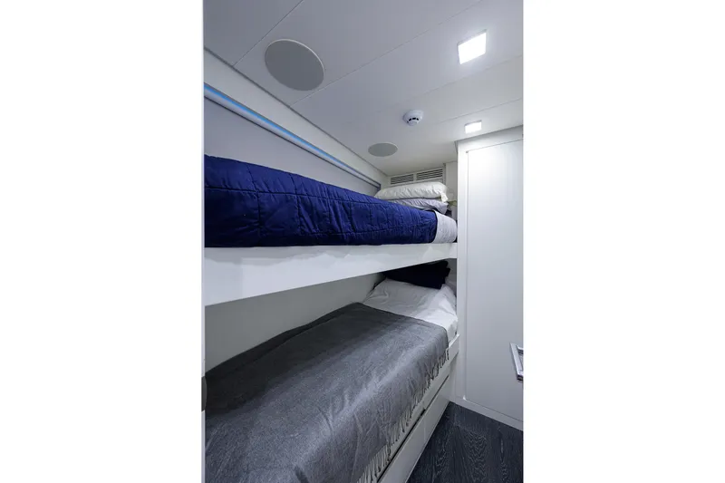 Shine Yacht Photos Pics Bunk beds in 2022 Pershing 9X yacht cabin, featuring modern design and cozy bedding.