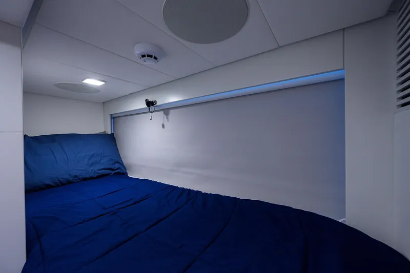 Shine Yacht Photos Pics Cozy cabin bed in 2022 Pershing 9X yacht with blue bedding and modern lighting.