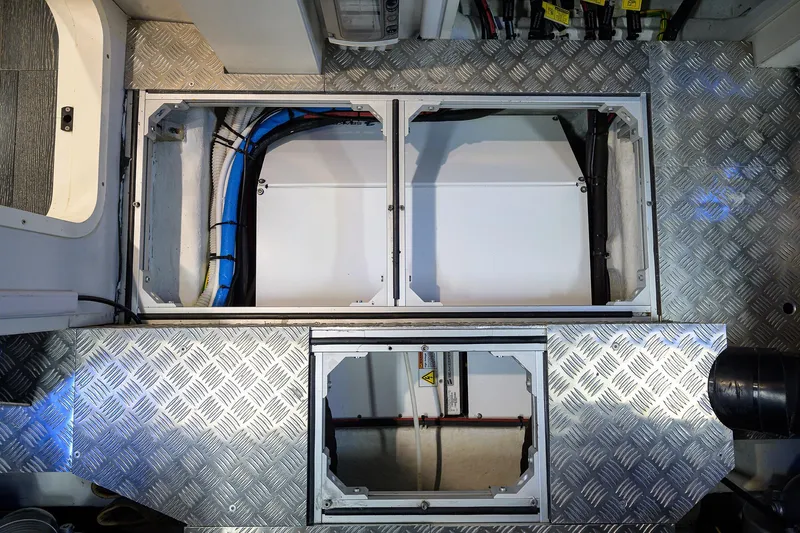 Shine Yacht Photos Pics Engine compartment of 2022 Pershing 9X yacht with visible wiring and metal flooring.