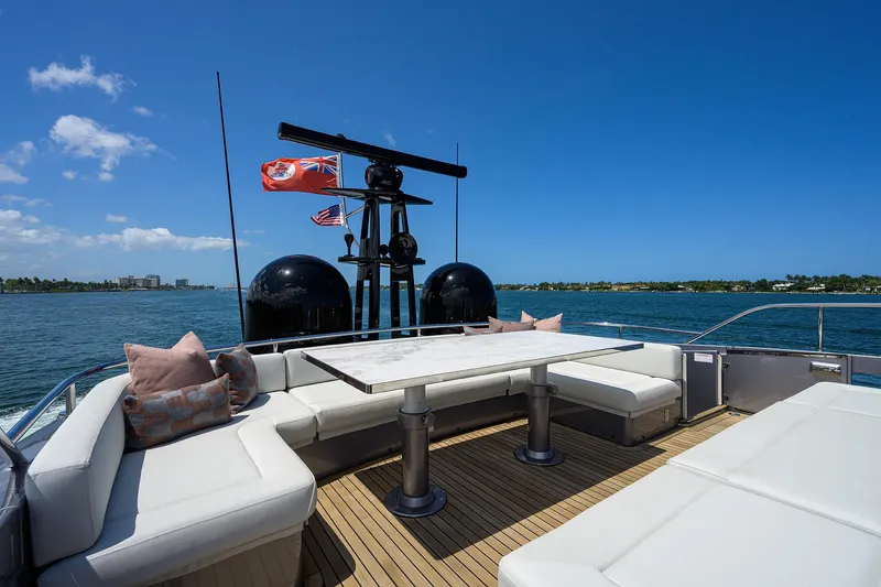 Shine Yacht Photos Pics Luxurious 2022 Pershing 9X yacht deck with seating, table, and ocean view.