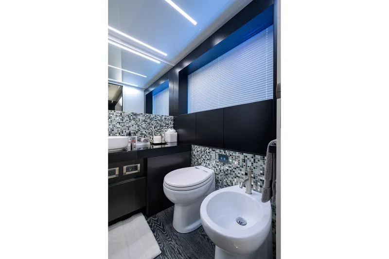 Shine Yacht Photos Pics Luxurious bathroom in 2022 Pershing 9X yacht with modern fixtures and mosaic tiles.