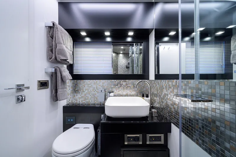 Shine Yacht Photos Pics Luxurious bathroom in 2022 Pershing 9X yacht with modern fixtures and mosaic tiles.
