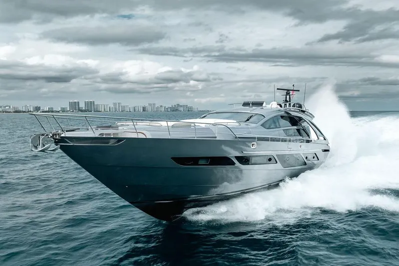 Shine Yacht Photos Pics 2022 Pershing 9X yacht cruising on open water with city skyline in background.