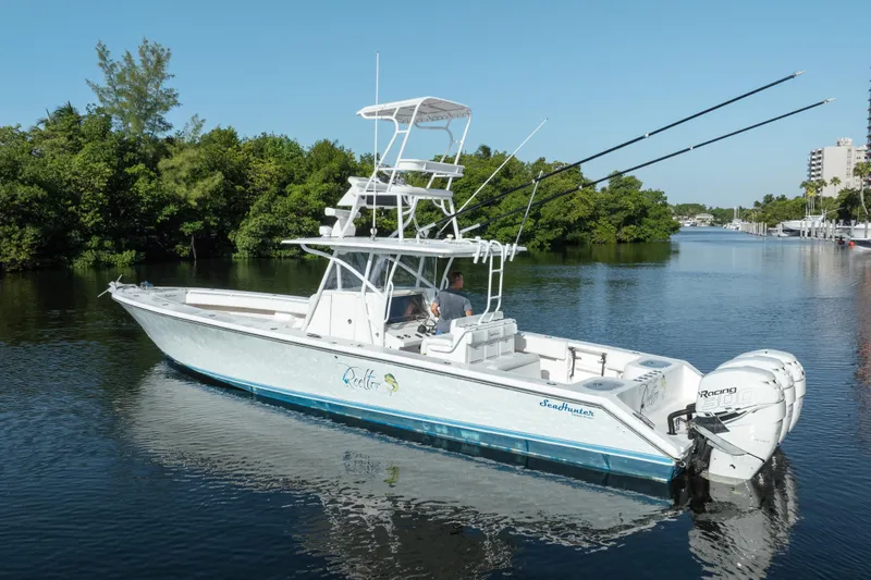  Yacht Photos Pics 2009 SeaHunter 40 boat on calm water, featuring dual outboard engines and fishing rods.