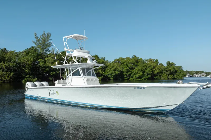  Yacht Photos Pics 2009 SeaHunter 40 boat on calm water, surrounded by lush greenery.
