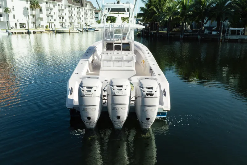  Yacht Photos Pics 2009 SeaHunter 40 boat with triple outboard engines docked in a serene marina.