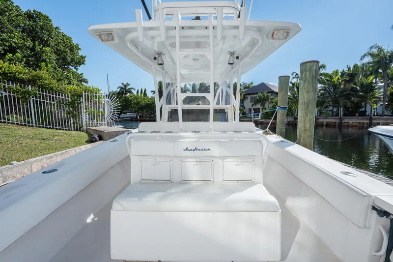  Yacht Photos Pics 2009 SeaHunter 40 boat interior with seating, docked near lush greenery and waterfront homes.